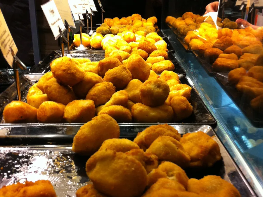Bandejas de croquetas caseras rebozadas en un mostrador