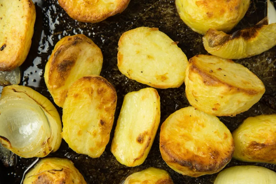 Patatas asadas y doradas en una bandeja de horno